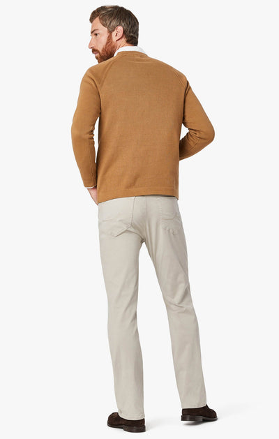 Man with back turned, wearing 34 Heritage Dawn Twill straight leg pants and a tan sweater, paired with brown shoes from 34 Heritage, posed against a white background.