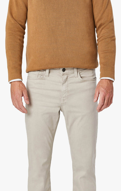 A person is shown from shoulders to mid-thigh, facing forward, wearing the 34 Heritage Dawn Twill light beige straight-leg pant by 34 Heritage and a brown long-sleeve shirt.