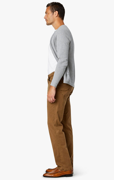 A man in profile wears 34 Heritage Tobacco Twill comfort rise straight leg pants, a light gray cardigan, white shirt, and brown shoes against a plain white background.