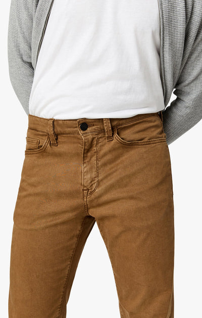 A person wearing 34 Heritage Tobacco Twill comfort rise straight leg pants, a white t-shirt, and a light gray cardigan with their hands behind their back.