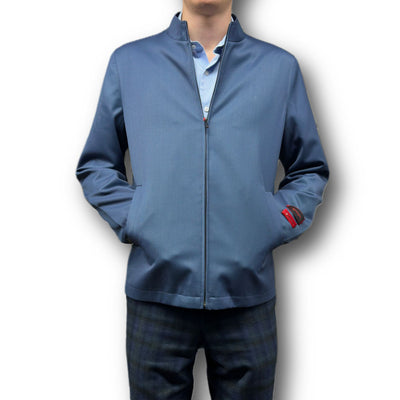 A person wears the Mattarazi Coat Paolo light blue zip-up jacket by Mattarazi over a matching shirt and dark plaid pants, standing with hands in pockets against a white background.