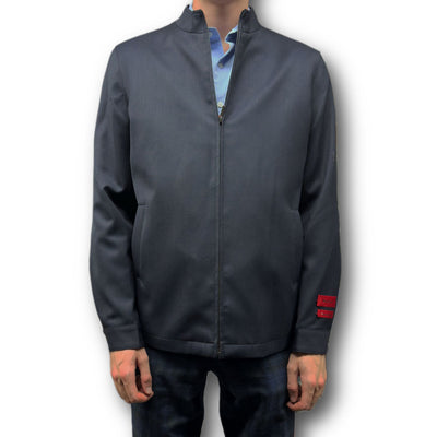 A person wearing the Mattarazi Coat Paolo by Mattarazi over a light blue shirt and dark pants, standing against a plain white background.