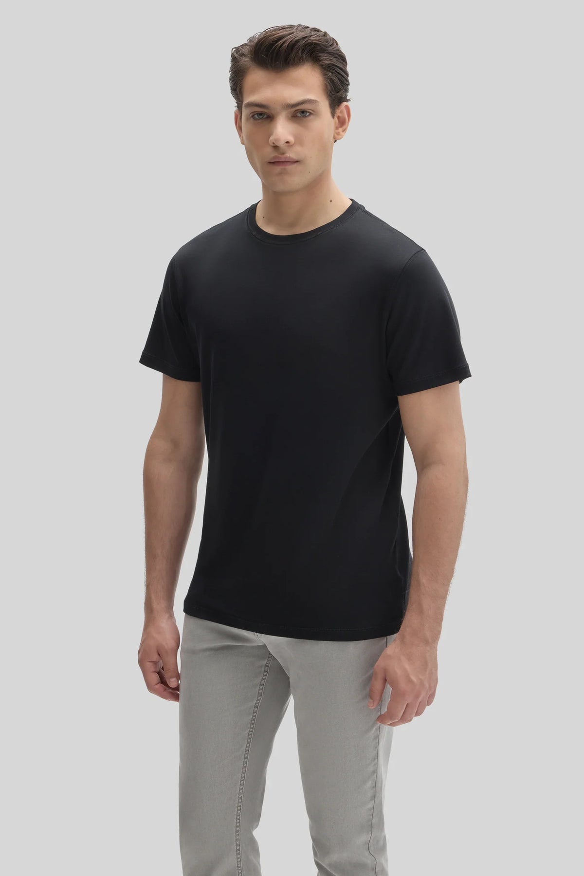 A man wearing a black Robert Barakett Tee Shirt Georgia Crew 23336 and grey pants.