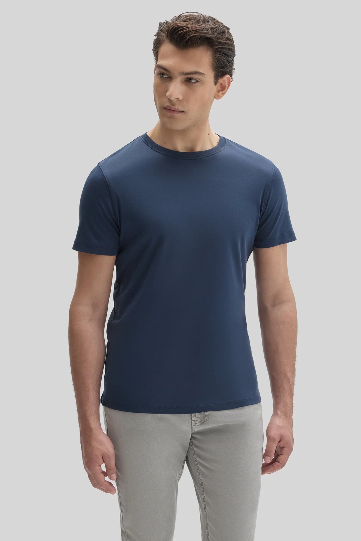 A man wearing a navy blue Robert Barakett Tee Shirt Georgia Crew 23336 and grey pants.