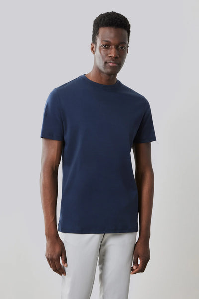 A man stands against a plain background wearing a navy blue Robert Barakett Georgia Crew 23336 Tee, made from premium Pima cotton, paired with light gray pants.