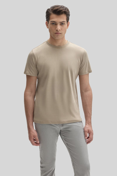 A man wearing a tan Robert Barakett Tee Shirt Georgia Crew 23336 and grey jeans.