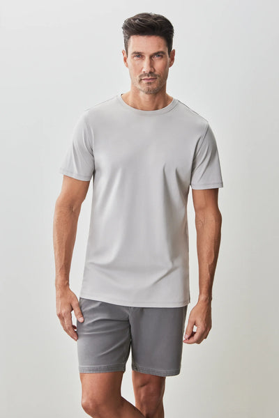 A man stands against a light background, wearing a grey Robert Barakett Georgia Crew Tee and matching shorts—a premium Pima cotton shirt for a polished yet comfortable look.