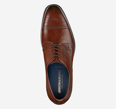 The Johnston & Murphy Ellsworth Cap Toe is a brown leather Oxford with brogue toe detailing, dark laces, enhanced cushioning, a leather outsole, and a visible branded insole.