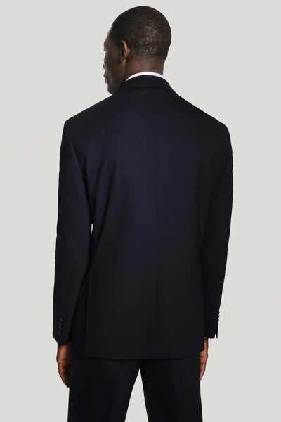A man is shown from the back, wearing the Jack Victor Solid Wool Suit by Jack Victor, standing against a plain light grey background.
