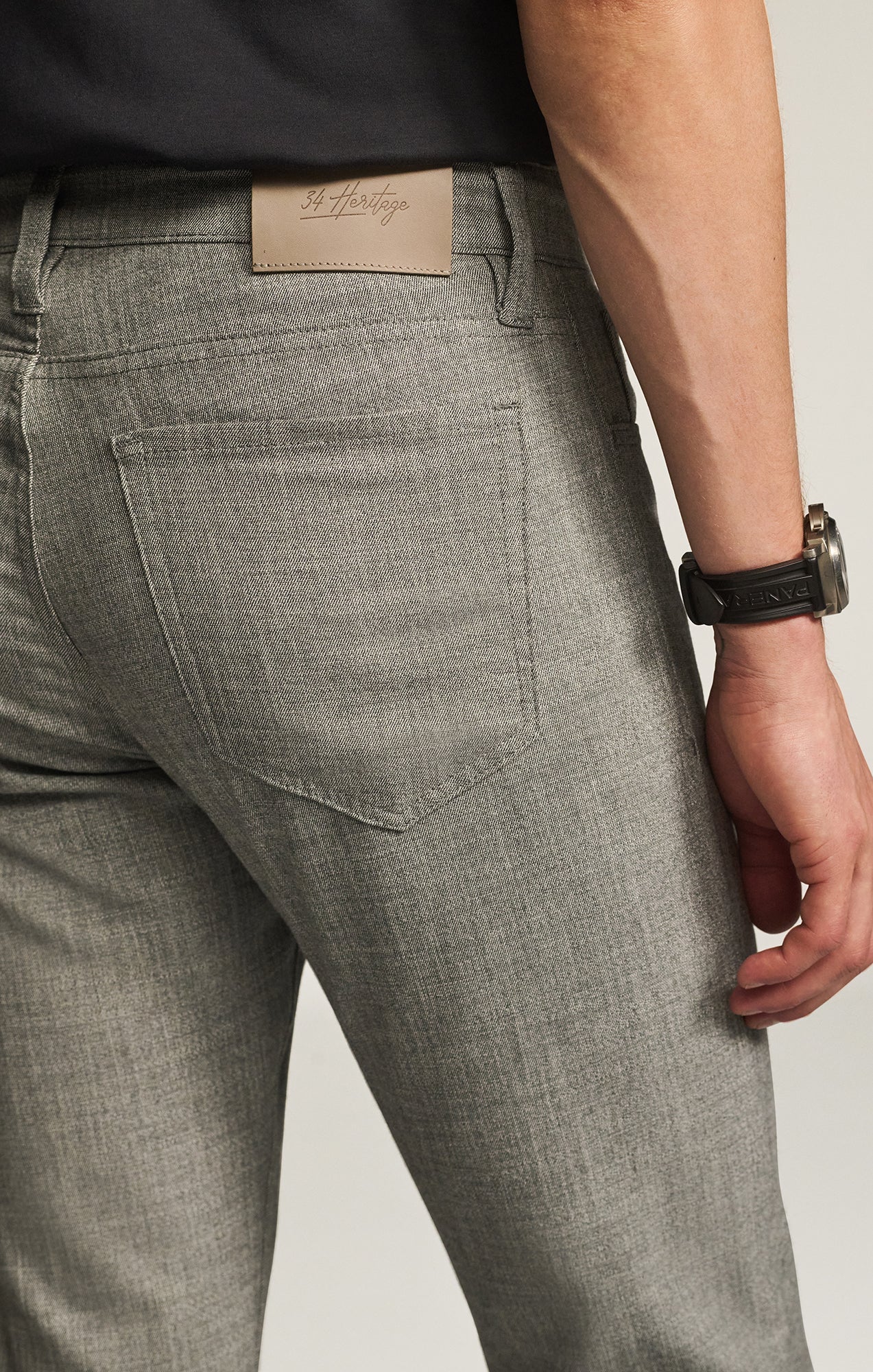 Gray pants with a 34 Heritage label on the back pocket against a neutral background