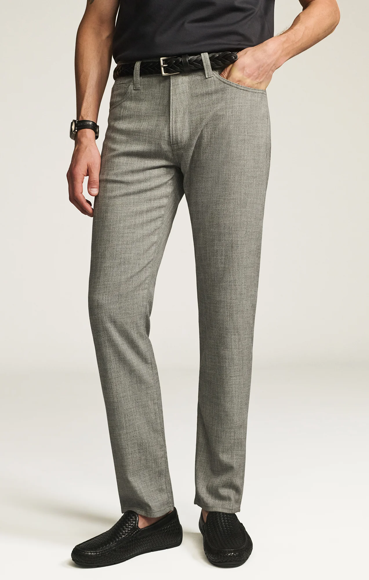 Person wearing gray checkered pants with a plain background