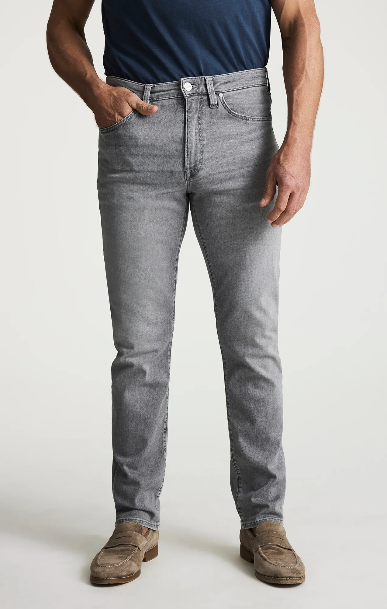 Person wearing gray jeans and a navy shirt on a white background