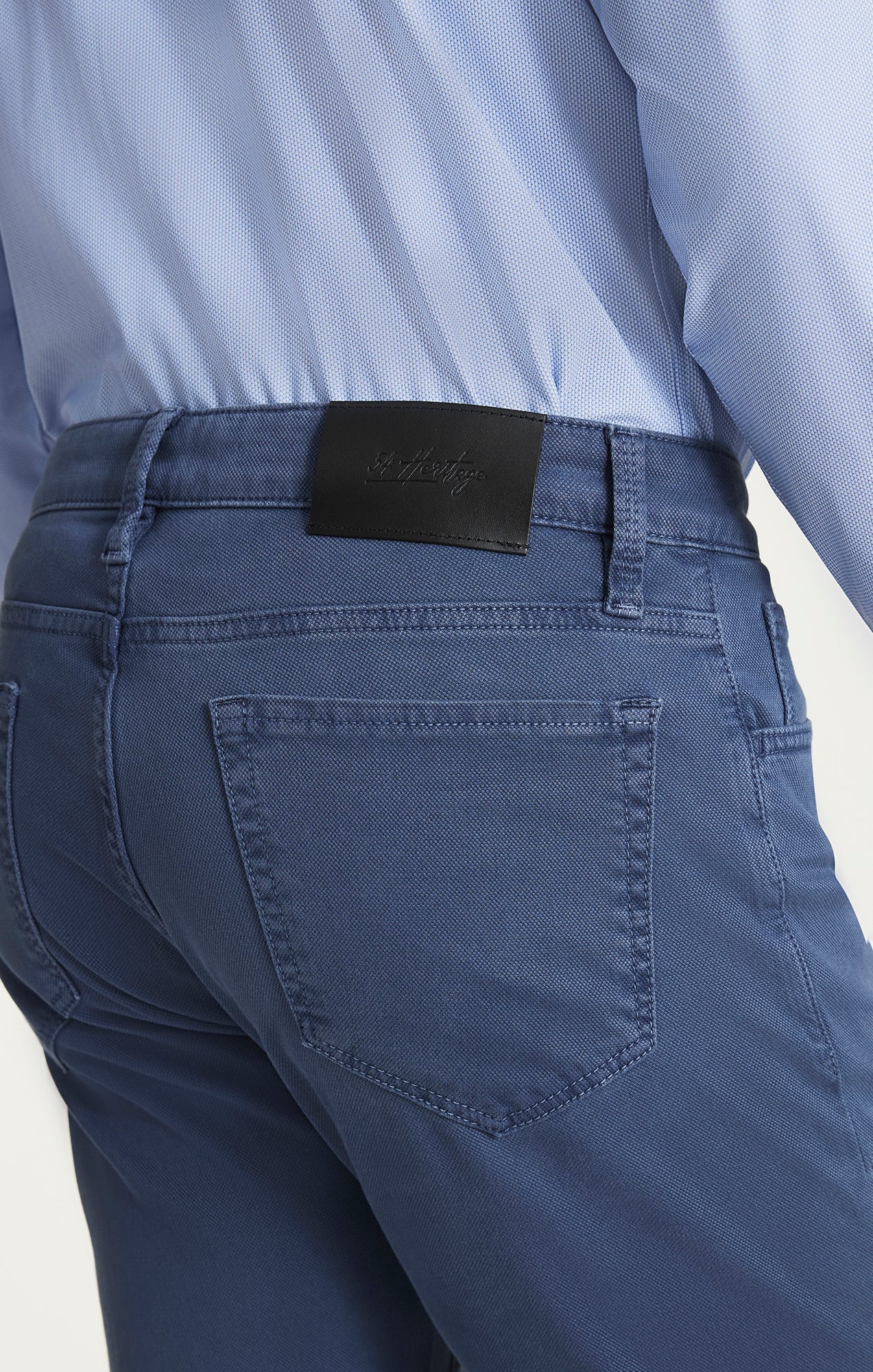 Blue jeans with a visible brand label on a light gray background