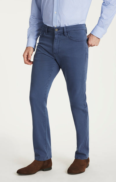 Person wearing blue jeans and a light blue shirt on a white background