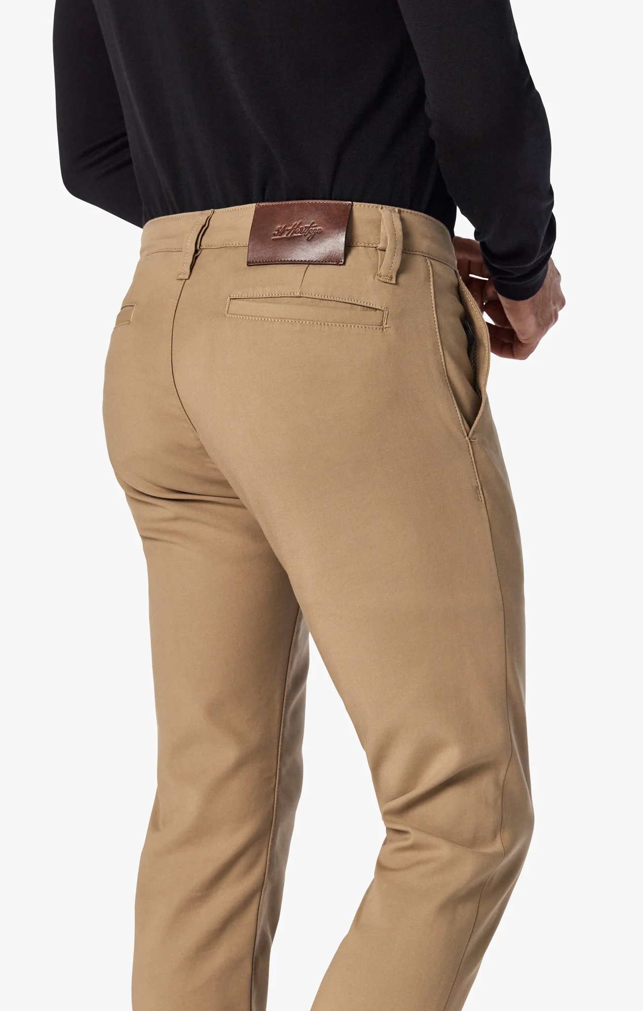 Beige pants worn by a person on a white background