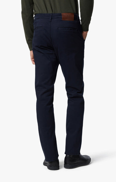 A person is shown from the back against a plain white background, wearing 34 Heritage Charisma Navy Twill Jeans by 34 Heritage, paired with a dark green top and black shoes.