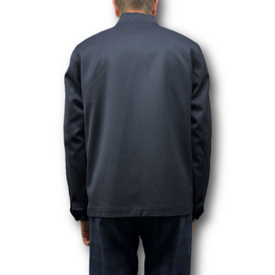 A person faces away, wearing the Mattarazi Coat Paolo by Mattarazi, paired with plaid pants, against a plain white background.