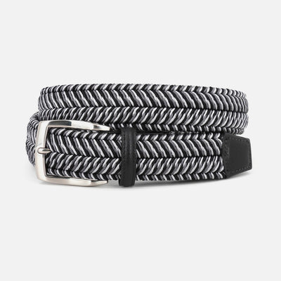 The Torino Italian Woven Herringbone Stretch Belt features a black and white design with a silver buckle, black leather details, and glove leather lining by Torino, shown coiled neatly on a white background.