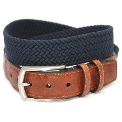 A saddle tan leather belt with a silver buckle is coiled on top of a Torino Italian Woven Cotton Elastic Belt in navy blue.