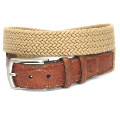 A tan Torino Italian Woven Cotton Elastic Belt is coiled on top of a saddle tan Torino leather belt with a silver buckle.