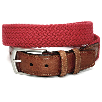A Torino Italian Woven Cotton Elastic Belt, in red with a brown saddle tan leather buckle strap and a silver buckle, coiled in a loop.