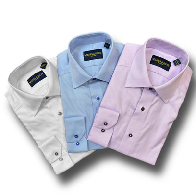 Three neatly folded Wilkes & Riley Herringbone Dress Shirts Big & Tall in white, light blue, and light purple are arranged side by side on a white background for a wrinkle-free, polished look.