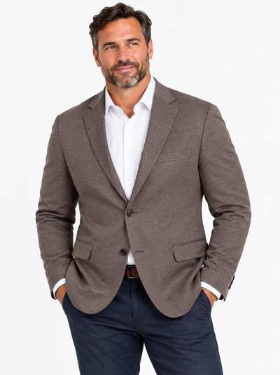 Man with a beard wears the 7 Downie St Alden Sport Coat Big & Tall, a white dress shirt, and navy trousers, standing with hands in pockets against a white background.