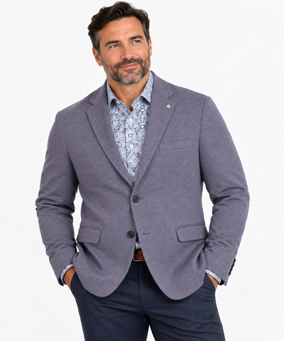 Man wearing a 7 Downie St Alden Sport Coat Big & Tall, patterned dress shirt, and navy pants, standing with hands in pockets against a white background.