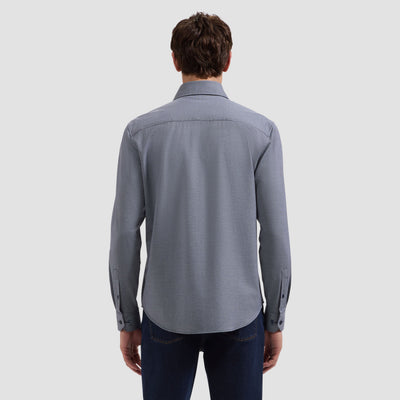Person wearing a gray button-up shirt on a light gray background