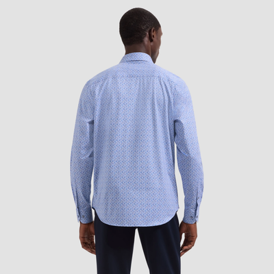 Man wearing a blue patterned shirt on a light gray background