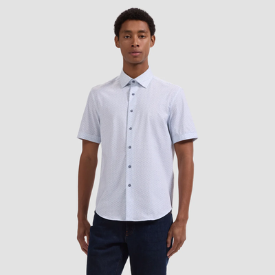 Man wearing a light gray short-sleeve button-up shirt against a plain background