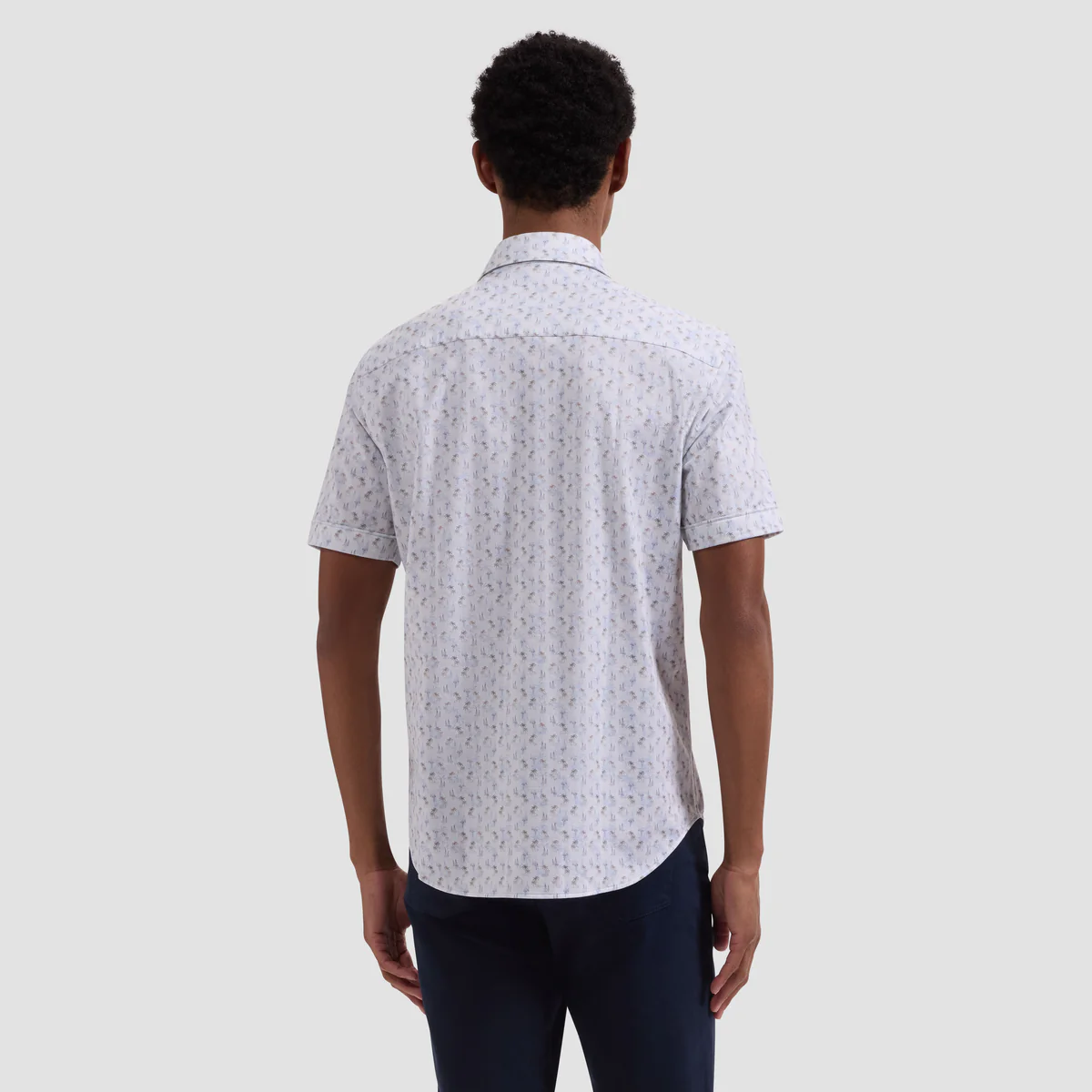 Man wearing a patterned short-sleeve shirt on a plain background