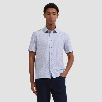 Man wearing a patterned short-sleeve shirt against a plain background