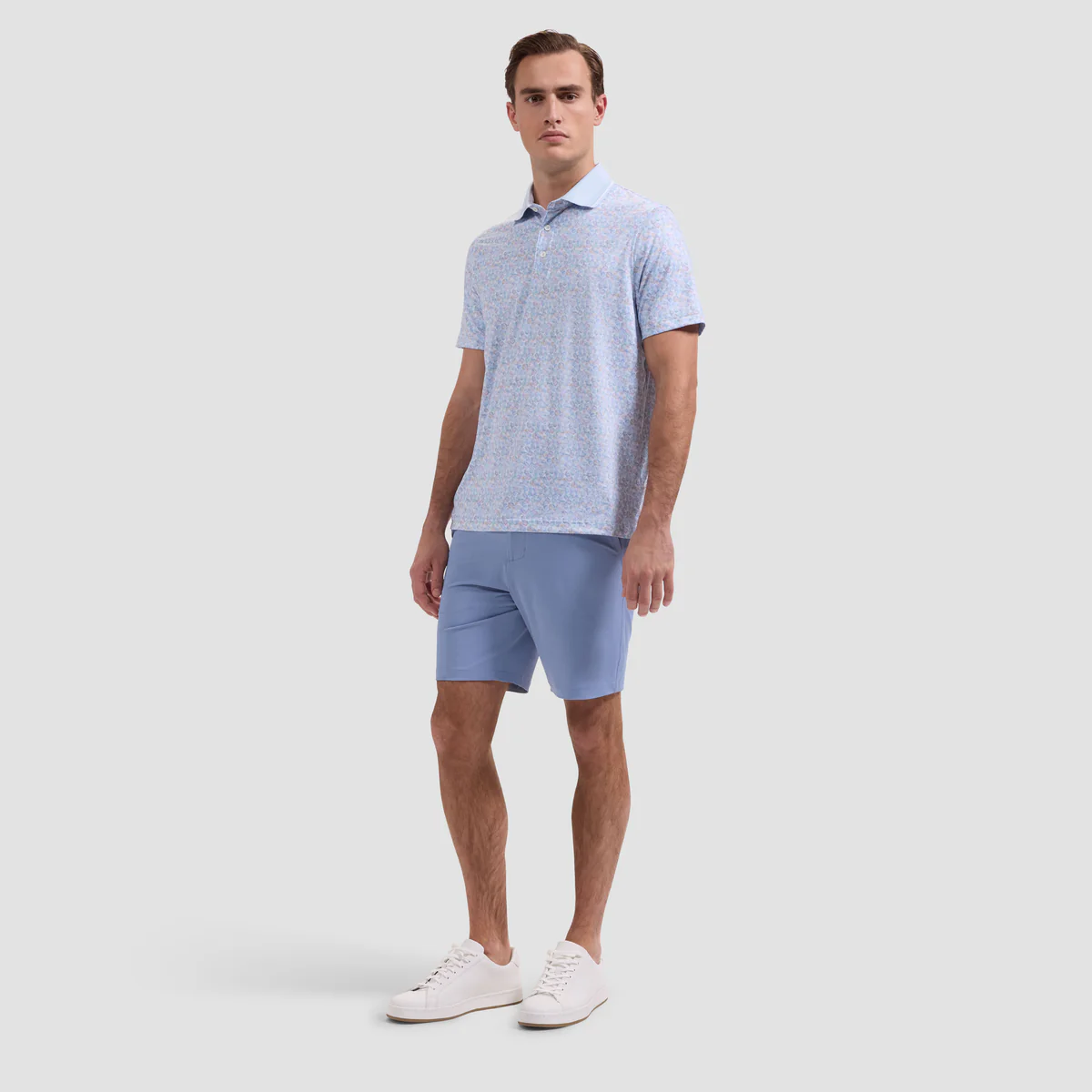 Man wearing a light blue polo shirt and shorts on a white background