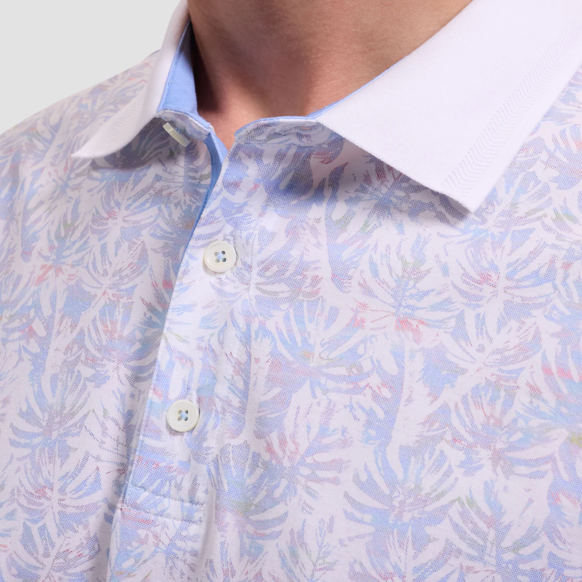 Close-up of a patterned shirt with a white collar and buttons.