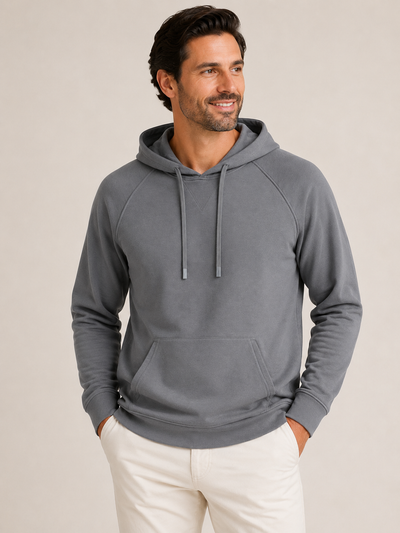 A man wearing the Georg Roth Scuba Hoodie Big & Tall, a dress-casual gray hooded sweatshirt by Georg Roth featuring drawstrings and a front pocket, stands with his hands in the pockets against a neutral background.