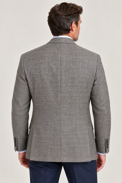 A man is shown from the back, standing against a plain, light background and wearing the Hart Schaffner Marx Grey and Brown New York Sport Coat 3900010 paired with dark blue trousers.