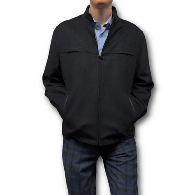 Wearing the black Enzo Coat Play by Enzo over a light blue shirt and dark plaid pants, hands in pockets, this person showcases refined luxury outerwear style against a white background.