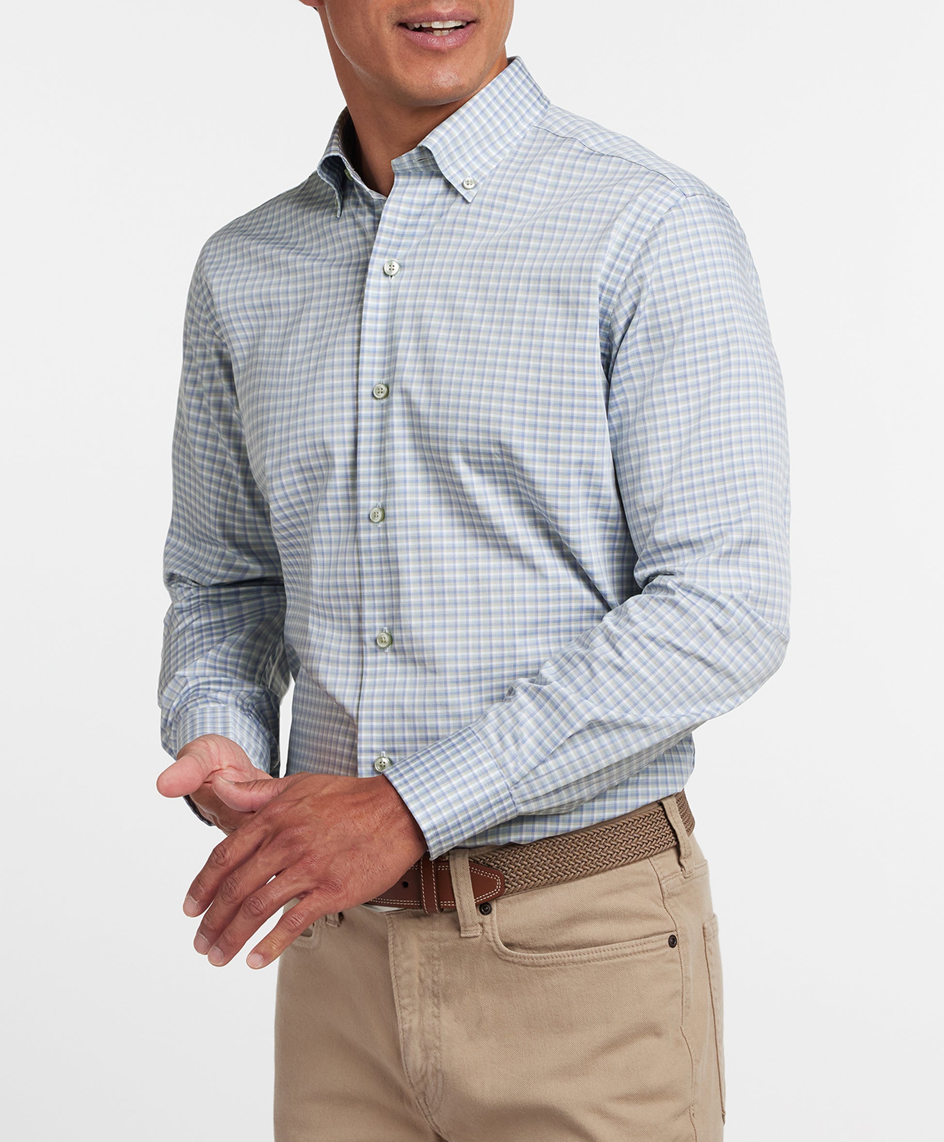 Man wearing a checkered shirt and beige pants on a white background