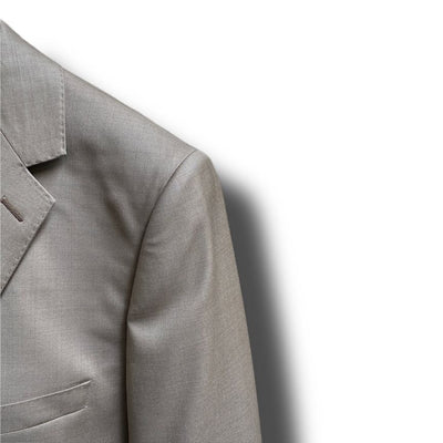 Close-up of the upper left section of the Paul Betenly Solid Suit - Slim Fit in light gray wool, featuring a notched lapel and part of a breast pocket, displayed against a white background with shadow.