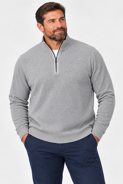Man wearing the F/X Fusion Men’s Big & Tall Thermal 1/4 Zip Sweater 13050 in light gray with dark blue pants, standing hands in pockets against a plain light background.