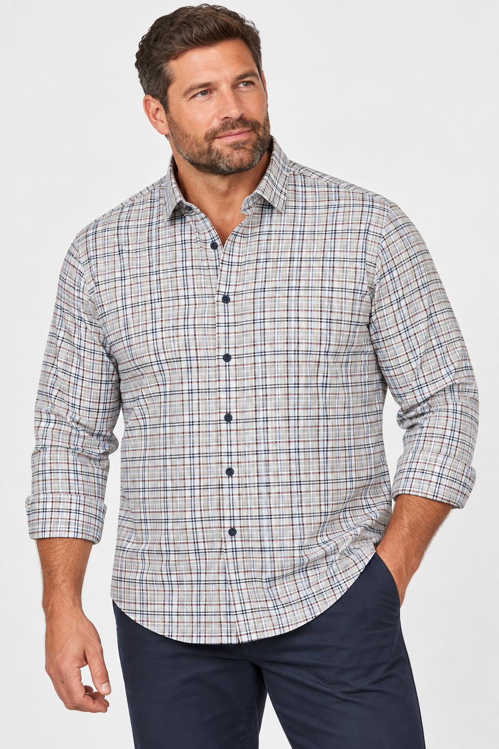 A man wearing the Johnnie-O Tahoe Plaid Flannel Shirt Big & Tall—a light-colored plaid button-up with dark buttons—from Johnnie-O, paired with dark pants, stands against a plain light background.