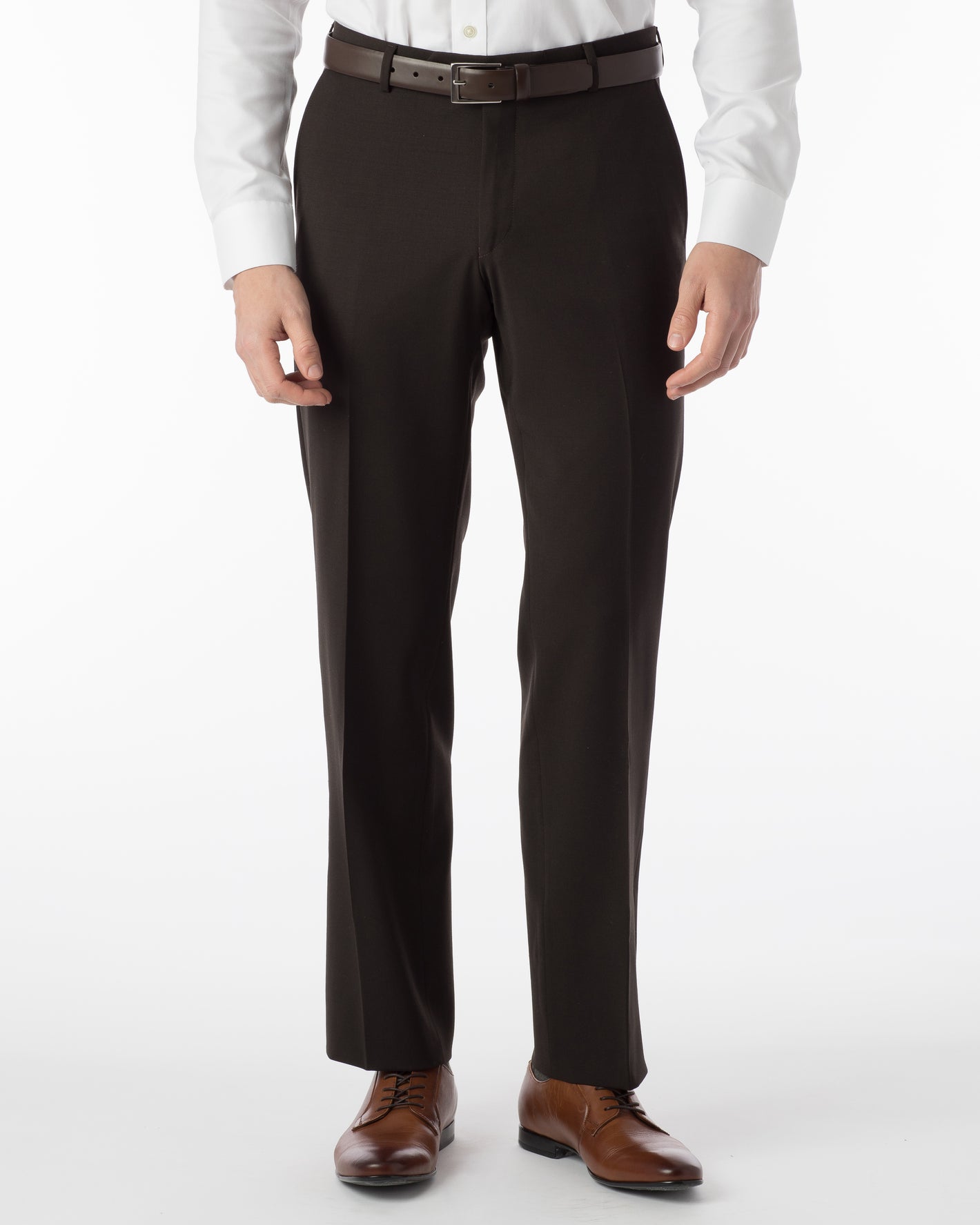 A man wears Ballin Super 120's Comfort-EZE Big & Tall brown dress pants by Ballin, paired with a white shirt, brown belt, and brown shoes, standing against a white background.
