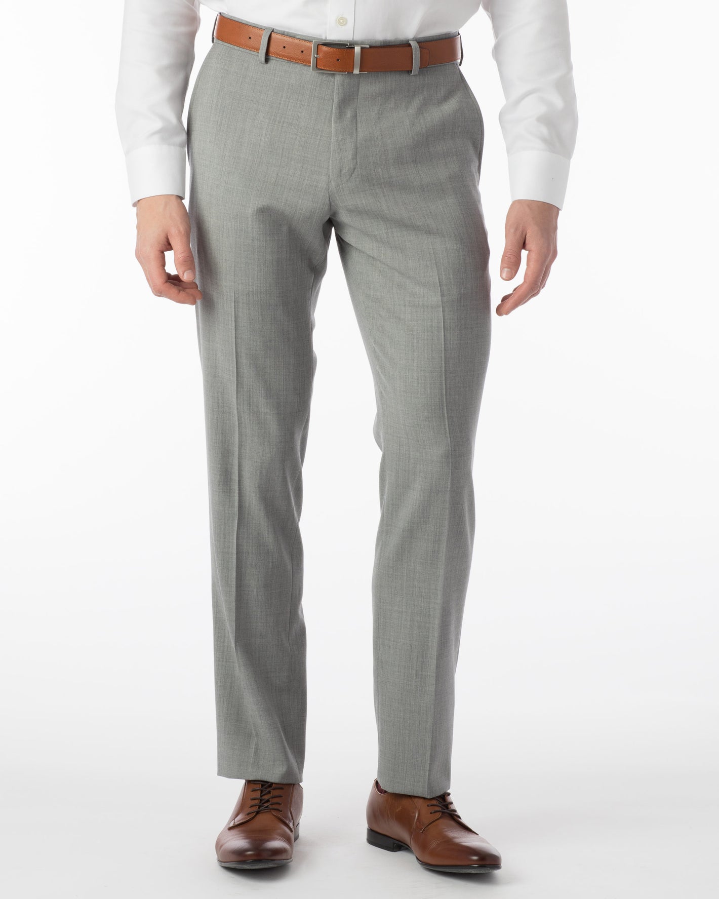 A person wearing Ballin Super 120's Comfort-EZE Big & Tall dress pants in Pearl Grey with a white shirt, brown belt, and brown dress shoes stands against a plain white background—an ideal travel office look by Ballin.