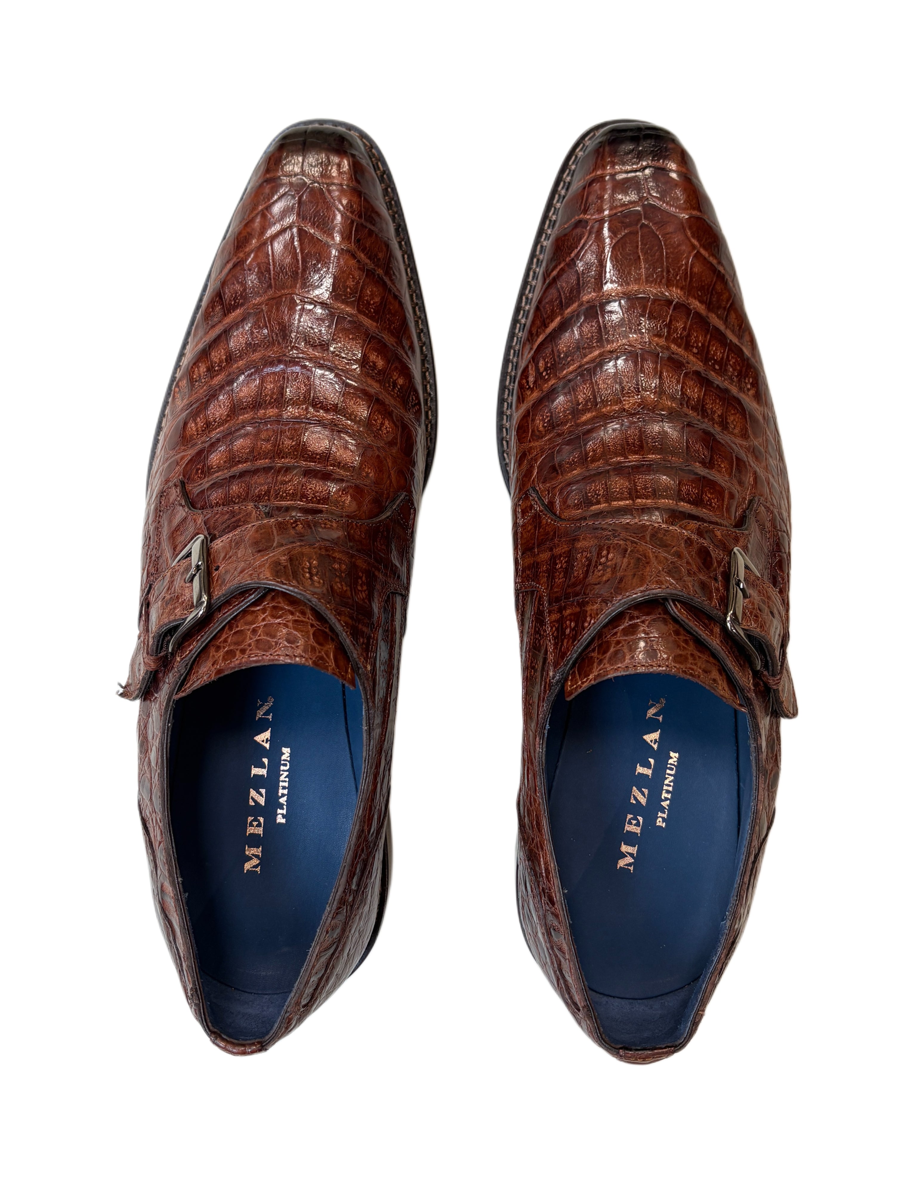 Brown crocodile-patterned dress shoes with blue insole on a white background