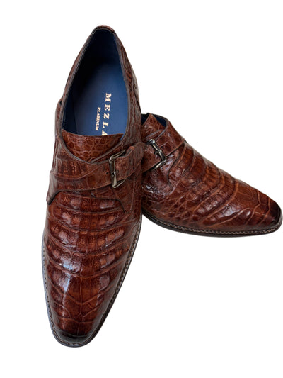 Brown leather dress shoes with a crocodile pattern on a white background