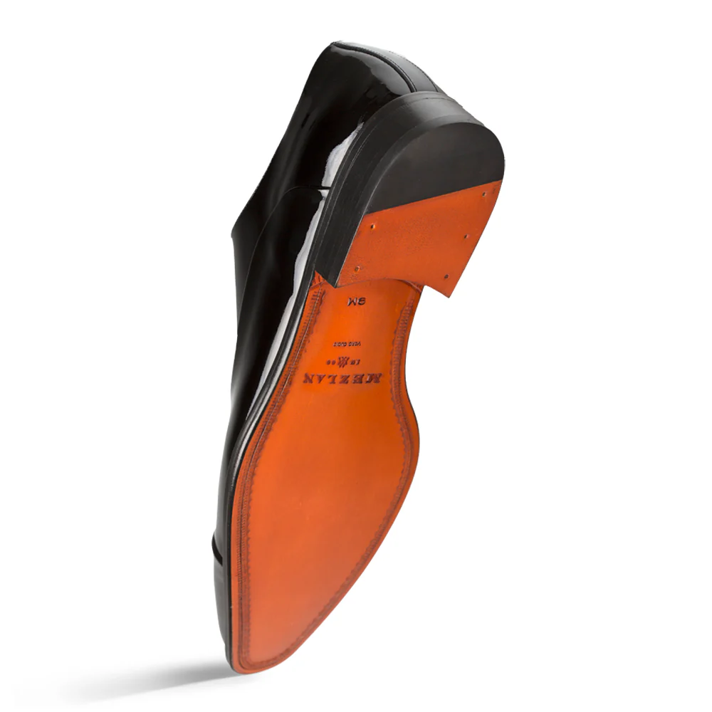 Close-up of a shoe sole with orange leather and black rubber on a white background