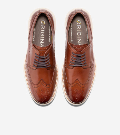 A pair of Cole Haan Grand Remastered Wingtip Oxford shoes by Ted's Clothiers, featuring brown brogued leather uppers, white soles, and dark laces, shown from above on a white background.