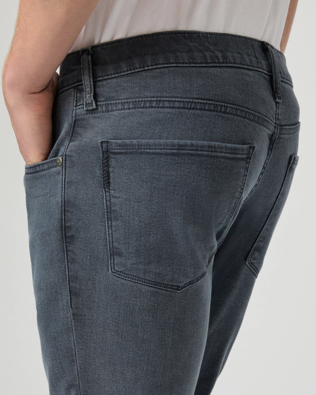 Close-up of dark gray jeans on a plain background