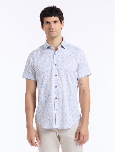 Man wearing a short-sleeve shirt with a light blue floral pattern on a white background